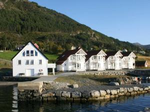 a row of white houses next to a body of water at 6 person holiday home in Åram-By Traum in Sandvik