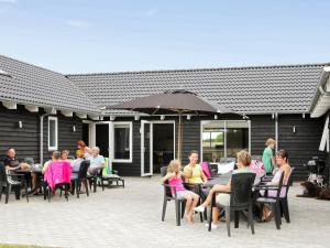 un grupo de personas sentadas en mesas en un patio en 20 person holiday home in Sydals, en Høruphav