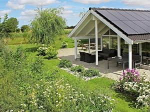 a gazebo in a garden with flowers at 12 person holiday home in Idestrup in Marielyst