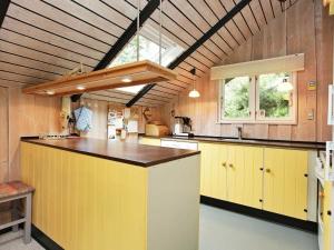 a large kitchen with yellow cabinets and a large window at 4 person holiday home in R dby in Kramnitse