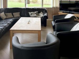 ein Wohnzimmer mit Sofas, einem Tisch und Stühlen in der Unterkunft 10 person holiday home in Ansager in Ansager