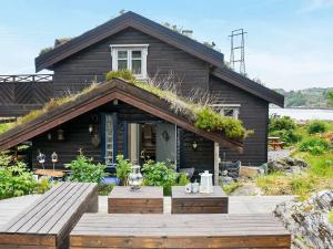 a house with a wooden deck in front of it at Holiday Home Rensvikholmen in Frei