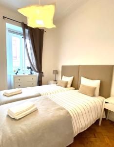 two beds sitting next to each other in a bedroom at Enjoy Mouraria Apartments in Lisbon