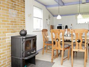 een keuken met een fornuis en een tafel en stoelen bij 6 person holiday home in L kken in Løkken