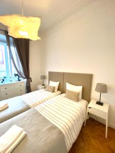 two beds in a room with two lamps and a bed sidx sidx sidx at Enjoy Mouraria Apartments in Lisbon