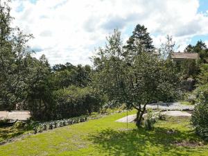 a garden with a tree and a stone wall at 4 person holiday home in H viksn s in Höviksnäs +28 photos