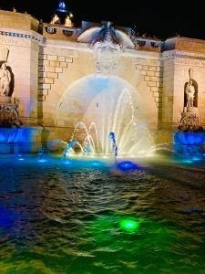 a fountain with lights in the water at night at Apartament Oliwia in Szczecin