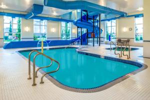 a swimming pool with a slide in a building at Microtel Inn & Suites by Wyndham Red Deer in Red Deer