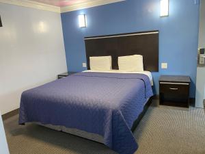 a blue bedroom with a bed with a blue wall at Golden West Manor Motel in Los Angeles