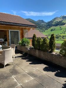 a patio with a table and chairs on a house at Pegasus in Zweisimmen