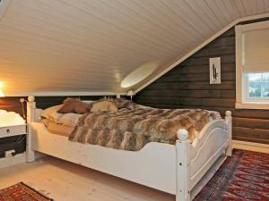 een slaapkamer met een groot bed op zolder bij Holiday Home Vestsiden III in Tromsnes