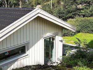 ein kleines weißes Haus mit einem Fenster darauf in der Unterkunft One-Bedroom Holiday home in Kållekärr in Apelgården