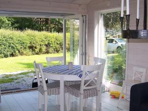 einen weißen Tisch und Stühle auf einer abgeschirmten Veranda in der Unterkunft One-Bedroom Holiday home in Kållekärr in Apelgården