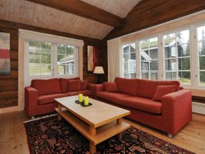 een woonkamer met twee rode banken en een salontafel bij 8 person holiday home in F vang in Tromsnes