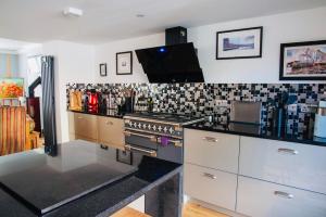 eine Küche mit Herd und Arbeitsplatte in der Unterkunft Boutique cottage central Wells in Wells + 17 Fotos