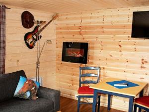 GravdalにあるOne-Bedroom Holiday home in Gravdalのリビングルーム(ソファ、テーブル、ギター付)