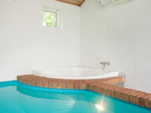 uma banheira num quarto com água azul em 8 person holiday home in Hj rring em Lønstrup