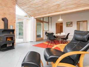 8 person holiday home in Hj rring في لونستروب: غرفة معيشة بها موقد وكراسي وطاولة