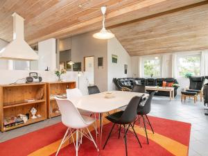 kuchnia i salon ze stołem i krzesłami w obiekcie 8 person holiday home in Hj rring w mieście Lønstrup