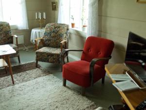 a living room with a red chair and a table at Holiday Home Nedre II in Eidsdal