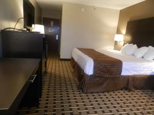 ein Hotelzimmer mit einem Bett und einem Flachbild-TV in der Unterkunft Haven Inn & Suites in Duluth
