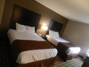德盧斯的住宿－哈維恩套房酒店，酒店客房设有两张床和两盏灯。