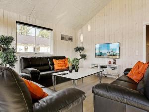 sala de estar con muebles de cuero y mesa en 18 person holiday home in Vejby en Vejby
