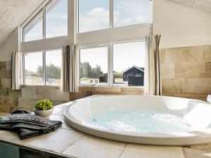 y baño con bañera grande y ventanas. en 18 person holiday home in Vejby en Vejby