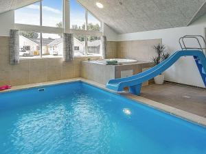 a swimming pool with a slide in a bathroom at 16 person holiday home in Hasselberg in Kappeln