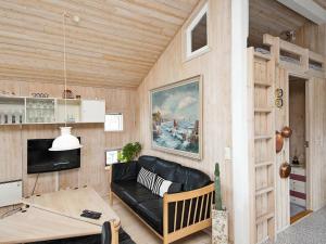ヒュールスミンネにある6 person holiday home in Juelsmindeのリビングルーム(黒い革張りのソファ、テーブル付)