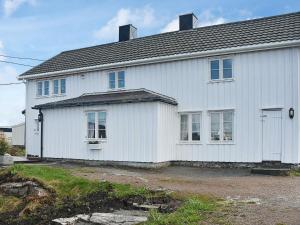 una casa blanca con muchas ventanas en Holiday Home Reksundveien en Henda