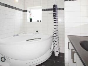 Baño blanco con bañera y lavamanos en 8 person holiday home in Hemmet, en Hemmet