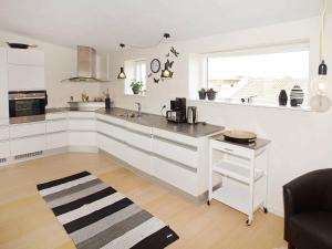 a white kitchen with a sink and a counter at 8 person holiday home in Hemmet in Hemmet