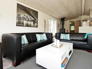 Jerupにある6 person holiday home in Jerupのリビングルーム(黒い革張りのソファ、テーブル付)