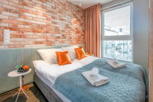 una camera da letto con un grande letto con asciugamani di Megi & Greg Apartments a Danzica
