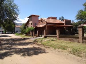 una casa en un camino de tierra al lado de un edificio en Complejo Norte en Merlo