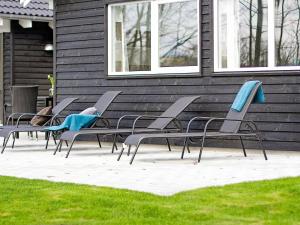 a group of chairs sitting outside of a house at 18 person holiday home in Hasselberg in Kappeln