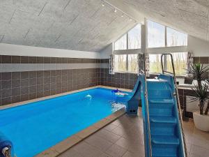 a large swimming pool with a slide in a room at 18 person holiday home in Hasselberg in Kappeln