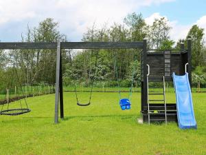 um parque infantil com dois baloiços num campo em 8 person holiday home in Hadsund em Hadsund