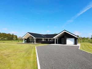 uma grande casa preta com um grande campo de relva em 8 person holiday home in Hadsund em Hadsund