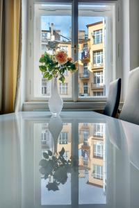 wazon z kwiatem na stole przed oknem w obiekcie Kaprova 5 - Old Town Apartments w Pradze