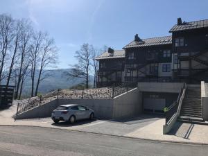 auf einem Parkplatz vor einem Gebäude geparkt in der Unterkunft Górskie Klimaty Myśliwska in Karpacz