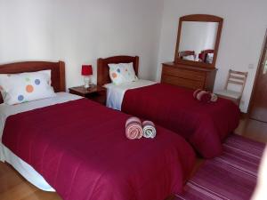 ナザレにあるHouse Victoriaのベッドルーム1室(赤いシーツと鏡付きのベッド2台付)