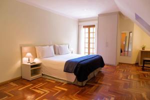 a bedroom with a bed and a dresser at Pousada Campos dos Holandeses - Campos do Jordao in Campos do Jordão