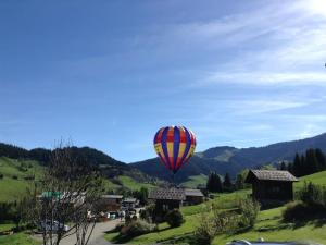 a hot air balloon in the sky over a village at Cosy chalet with garden in Notre-Dame-de-Bellecombe