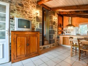 a kitchen with a tv on top of a wooden cabinet at Holiday Home Saint-Beauzire near Pauillac Castle in Saint-Beauzire +16 photos