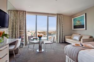 a hotel room with a bed and a table with chairs at The Olsen Melbourne Art Series in Melbourne