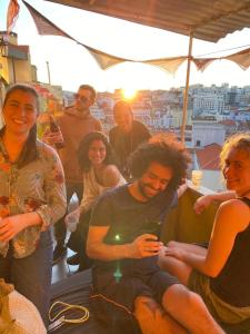 un gruppo di persone che posano per una foto sotto un ombrello di Lisbon Chillout Hostel Privates a Lisbona
