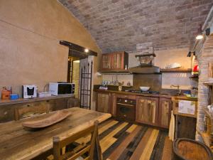 una cucina con tavolo in legno e muro di mattoni di Belvilla by OYO Villa Mezzeria a Guardea