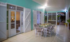 a dining room with a table and some chairs at Villa Joland in Sainte-Anne